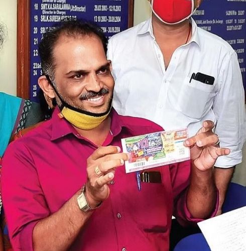 A photo of Sharafuddin holding his winning lottery ticket